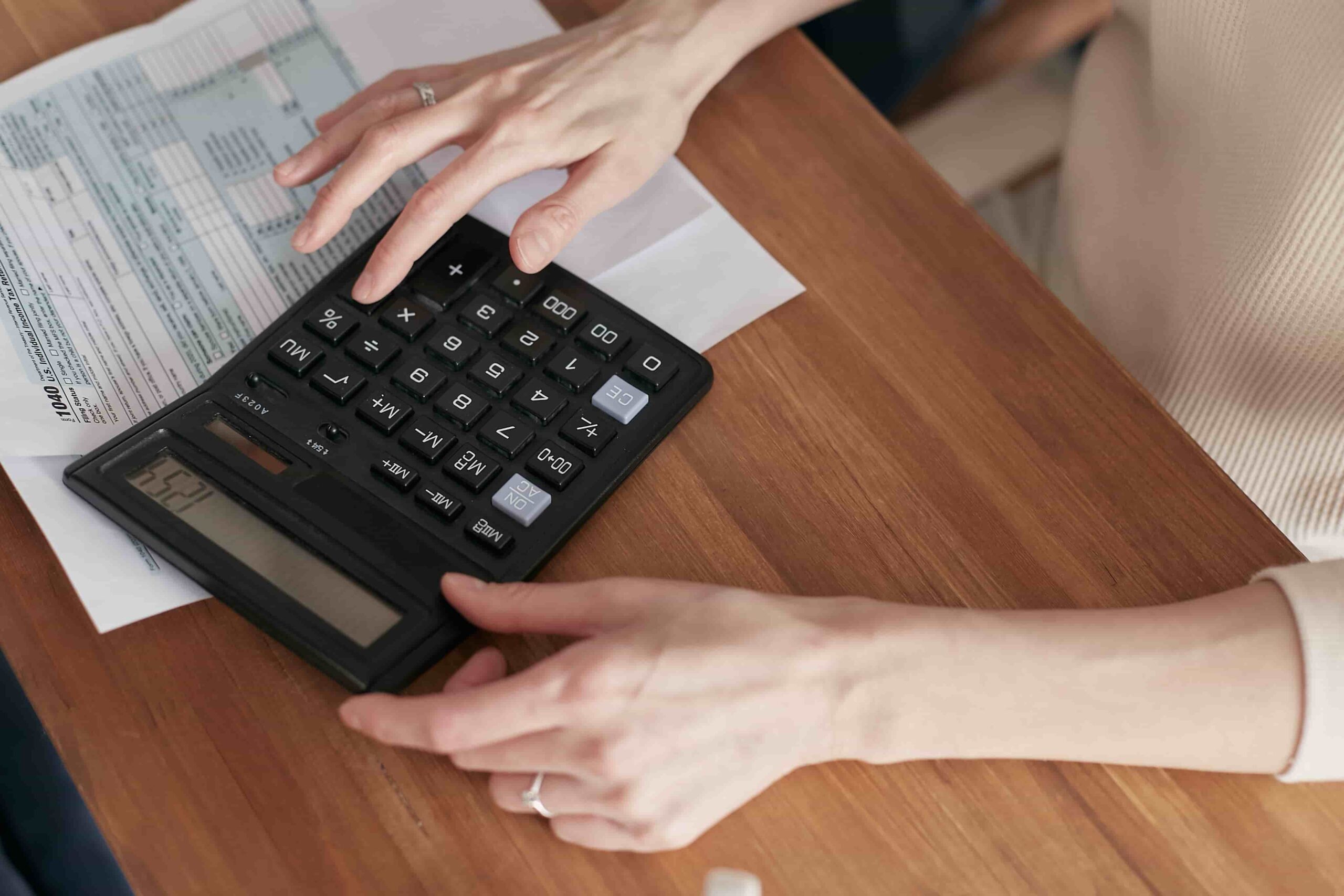Person figuring out their paycheck from salary using documents and a calculator