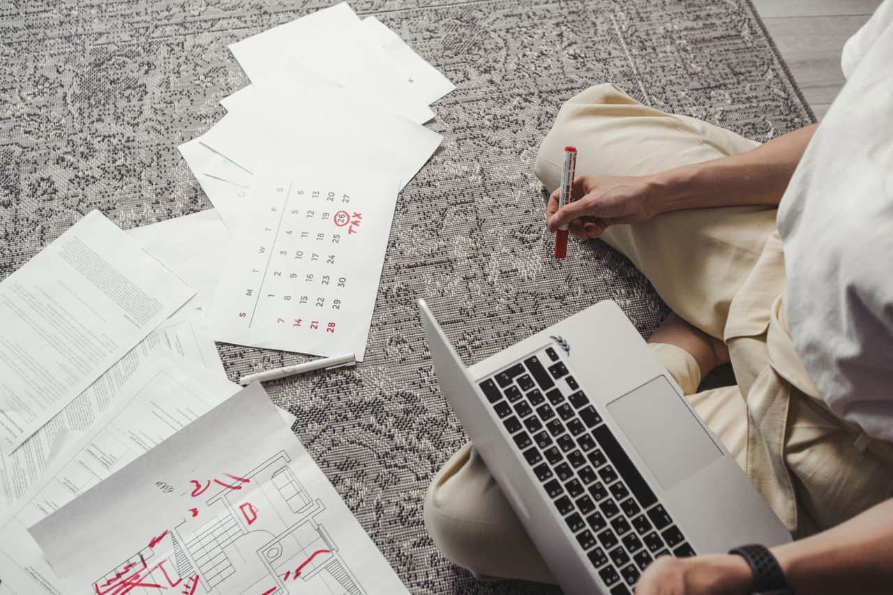 Person marking a CD maturity date on a calendar to avoid auto-renewal